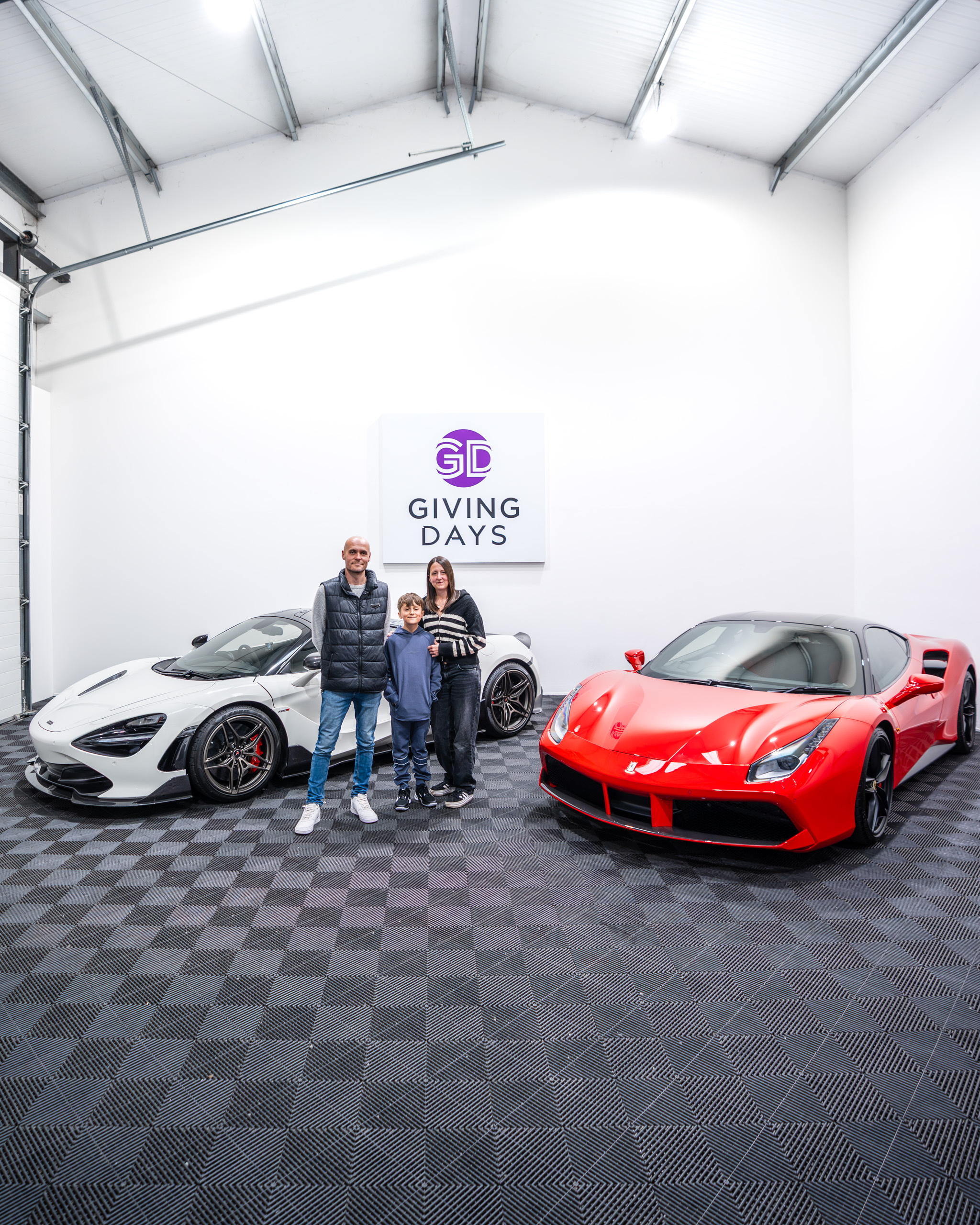 A family standing in front of a red ferrari car