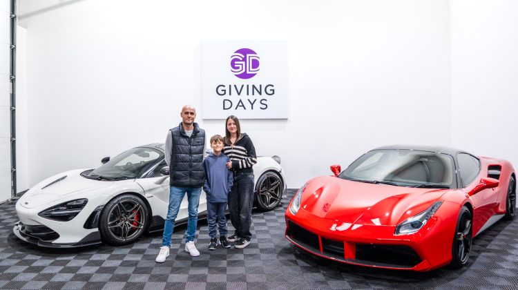 A family standing in front of a red ferrari car